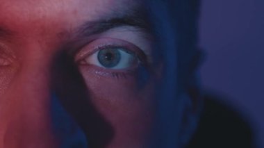 Ekrandaki ışığın gözündeki yakın çekim yansıması. Geceleri film izleyen genç adamın makro gözleri. Hızlı çalışan haber kaynağı.