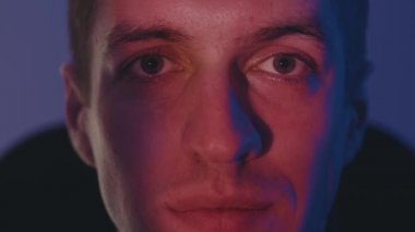TV 'de film izlerken ya da bilgisayar monitöründe görüntüsü olan genç adamın yüzünü kapatın. Geceleri video oyunu oynayan erkeklerin yakın çekim makrosu