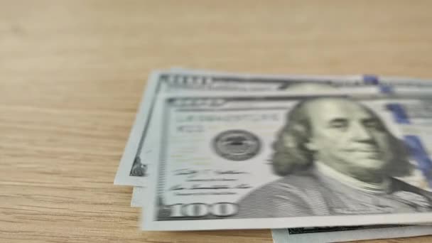 Zeitraffer des Zählens von Geld. Hundert amerikanische Dollar fallen auf den Tisch. Geldmacherkonzept — Stockvideo