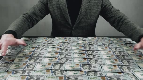 Hombre de negocios codicioso toma dinero de la mesa para su propio beneficio. Concepto de acumulación de dinero. — Vídeo de stock