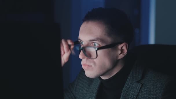 Geschockter und verängstigter Geschäftsmann nimmt panisch die Brille ab, verdeckt den Mund mit der Hand und blickt überrascht auf den Monitor, der schlechte Nachrichten liest. — Stockvideo