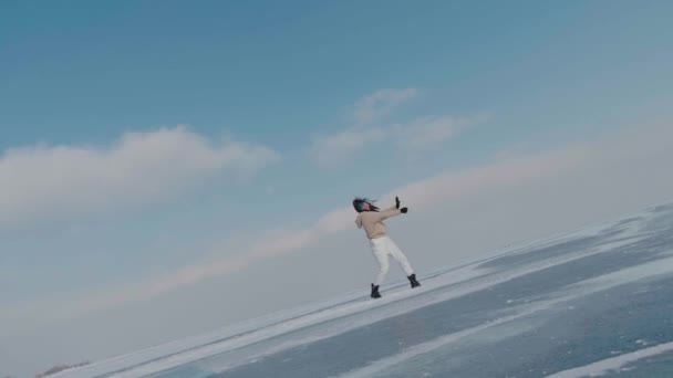 Stylowa młoda kobieta, profesjonalna tancerka, tańczący energiczny jazz funk lub hip hop na zamarzniętym jeziorze w mroźną zimę. Kobieta hipster tańczy wyzwanie dla sieci społecznych na pokrytej śniegiem zamarzniętej rzeki Arktyki — Wideo stockowe