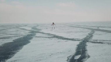 Şık genç bir kadın, profesyonel dansçı, dans eden enerjik caz funkı ya da soğuk kış mevsiminde Kuzey Kutbu donmuş gölünde hip hop. Dişi hipster, karla kaplı gölet veya nehirde sosyal ağlar için mücadele ediyor