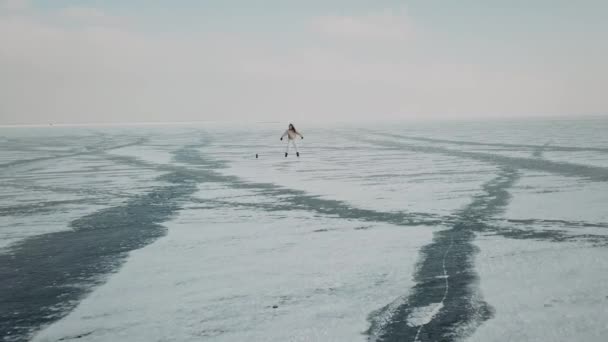 时尚的年轻女子，专业舞蹈家，在寒冷的冬季，在北极结冰的湖上跳着精力充沛的爵士舞。女性嬉皮士在白雪覆盖的池塘或河流上的社交网络上跳舞的挑战 — 图库视频影像