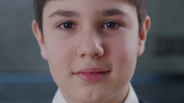 Retrato de close-up de 12-13 anos de idade menino olhando para câmera em casa. Closeup rosto de garoto bonito estudante com olhos castanhos dentro de casa — Vídeo de Stock