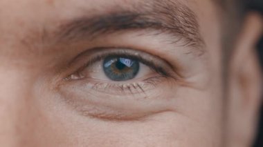 Kameraya bakan gülümseyen adamların yakın çekimi. Pozitif, mutlu bir erkeğin makro gözü..