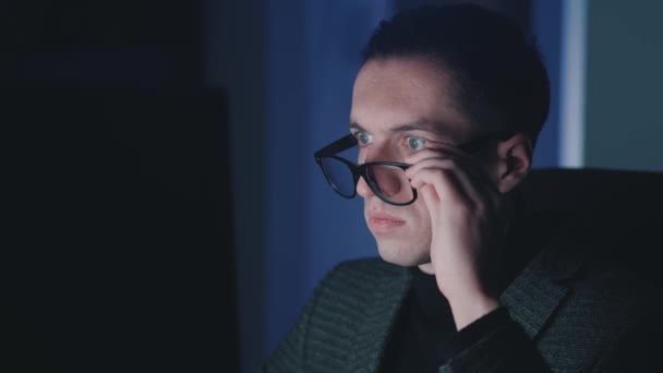 Empreendedor homem chocado em surpresa dispara óculos, cobre a boca com a mão e olha para tela do monitor de surpresa enquanto trabalhava no computador portátil à noite — Vídeo de Stock