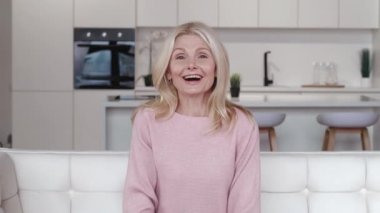 Güzel, yaşlı, yaşlı, kır saçlı, el sallayan, web kamerası konferansında el sallayan, evde sanal aile sohbeti yapan, web kamerası manzaralı yaşlı kadın..