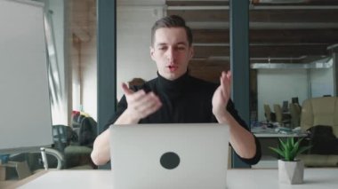 Gülümseyen iş adamı ofiste otururken bilgisayarını video konferansı için kullanıyor. Video görüşmesinde konuşan yakışıklı bir adam. Webcam şirketi toplantı konsepti.