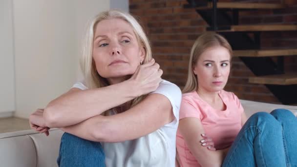 Ältere Mutter und ihre junge erwachsene Tochter kehren nach einem Konflikt auf dem Sofa um. Grollende Tochter und reife Mutter verärgert über Missverständnis. — Stockvideo