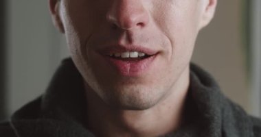 Şok olmuş genç adamın ağzı gülümsüyor, makro çekim. Gülümseyen adamın portresi..