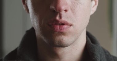 Şok olmuş genç adamın ağzı gülümsüyor, makro çekim. Gülümseyen adamın portresi..