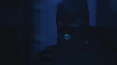 Gözlüklü bir bilgisayar programcısı, geceleri sunucuya siber saldırı. Ekrandan yansıyan ışık yüzüne yansıdı. Tehlikeli erkek sanal casus hackleme yazılımı karanlık odada.
