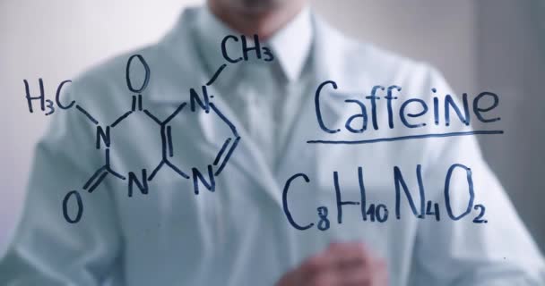 Omul de știință se gândește la soluția formulei chimice a cafeinei, desenată pe o placă de sticlă într-un laborator. Biochimistul de sex masculin rezolvă problema . — Videoclip de stoc