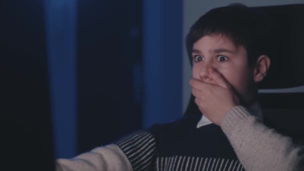 Φοβισμένο και σοκαρισμένο αγόρι κοιτάζει οθόνη οθόνης, καλύπτουν το στόμα με το χέρι του, ενώ χρησιμοποιώντας φορητό υπολογιστή αργά το βράδυ. Παιδί του σχολείου φοβάται τα κακά νέα, να διαβάσει τρομερό μήνυμα. Βλέποντας ταινία τρόμου. — Αρχείο Βίντεο