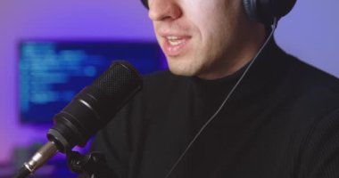 Podcast konsepti. Kulaklıkla konuşan, mikrofonla konuşan, stüdyoda video blogu kaydeden bir adam blogcusu.