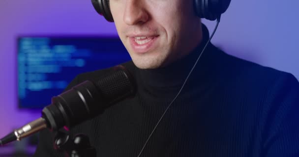 Крупним планом чоловічий блогер в навушниках, що розмовляють подкастом запису мікрофона в студії — стокове відео