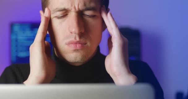 Detailní záběr stresu mladý nezdravý muž dotýká spánků, trpí bolestí hlavy migrény při práci na notebooku. Koncept přepracování — Stock video