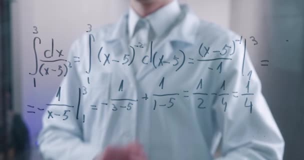 Человек-ученый размышляет над решением интегрального уравнения, нарисованного на стеклянной доске в лаборатории. Математик решает эту проблему.. — стоковое видео