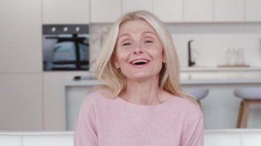 Güzel, yaşlı, yaşlı, kır saçlı, el sallayan, web kamerası konferansında el sallayan, evde sanal aile sohbeti yapan, web kamerası manzaralı yaşlı kadın..