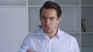 Kızgın işadamı işaret parmağıyla tehdit ediyor ve yumruğuyla tehdit ediyor. Tehlikeli bir adam boyun eğmeyi talep eder ve ofisinde durarak şiddet uygulamakla tehdit eder. Patron izlenmesini ve yönetilmesini ister.