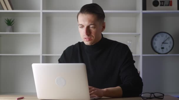Bilgisayarda çalışan odaklı iş adamı girişimci. Ofis masasında bilgisayar kullanan genç bir profesyonel. Modern defter aygıtı üzerinde çalışan meşgul bir işçi.. — Stok video