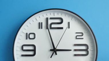 Yakın plan beyaz ofis saati mavi bir duvarda asılı..