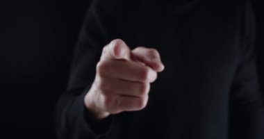 Kızgın adam işaret parmağıyla tehdit ediyor ve yumruğuyla tehdit ediyor. Tehlikeli adam boyun eğmeyi talep ediyor ve siyah arka planda şiddetle tehdit ediyor. Berbat bir patron izlenmeyi ve yönetilmeyi gerektirir.