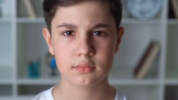 12-13 yaşlarındaki beyaz gömlekli bir çocuğun evdeki kameraya bakışının portresi. Yakışıklı okul çocuğu, yakın plan. — Stok video