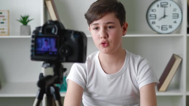 Boy videoblogger filme ny vlog video med professionelt kamera derhjemme. Kid vlogger optagelse video film til internettet. Ung blogger taler om videooptagelse. – Stock-video