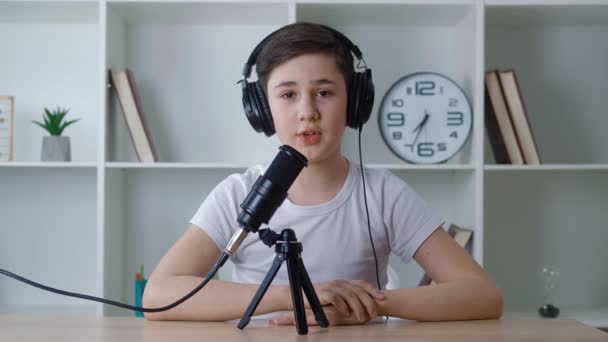 Junge Vlogger Blick auf Kamera und Aufnahme Podcast-Video für das Internet. Kid Videoblogger filmt neue Vlog-Video mit professionellem Mikrofon zu Hause. Junge Audio-Bloggerin spricht über Videodreh. — Stockvideo