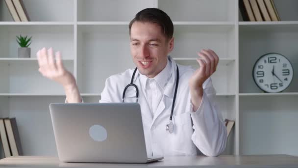 Male doctor talking to patient making video call on laptop.Man physician speaking looking at pc screen communicating by webcam in web chat consulting client online. Telemedicine concept — Stock Video