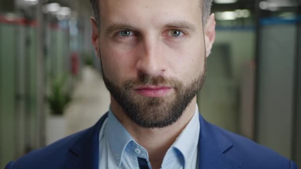 Close up of serious male boss with beard looking to camera. Portrait of good looking caucasian man in formal suit team leader in modern office. — стоковое видео