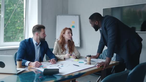 Motivated african american team leader explaining company development strategy to smiling colleagues. Happy multiracial business people working together at modern office. — Wideo stockowe