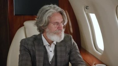Klasik takım elbiseli şık, olgun, milyoner bir adam özel uçakla uçuyor. Şirketin jet camından bakan kendine güvenen CEO iş adamı. Özel jetle seyahat eden lüks..