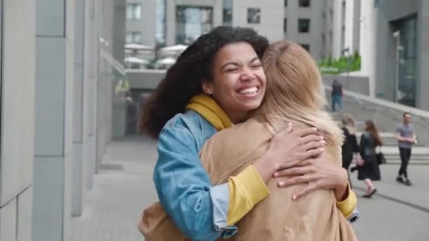 Twee jonge vrouwen ontmoeten en knuffelen op straat — Stockvideo