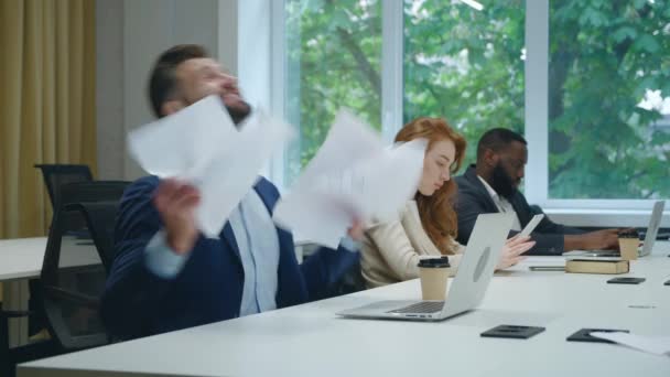 Emocionado hombre de negocios por increíbles buenas noticias en el ordenador portátil, tirar papeles de negocios mientras se divierten en la oficina. Hombre sorprendido celebrando buenos resultados delante de la computadora portátil en la oficina, mostrando sí signo — Vídeo de stock