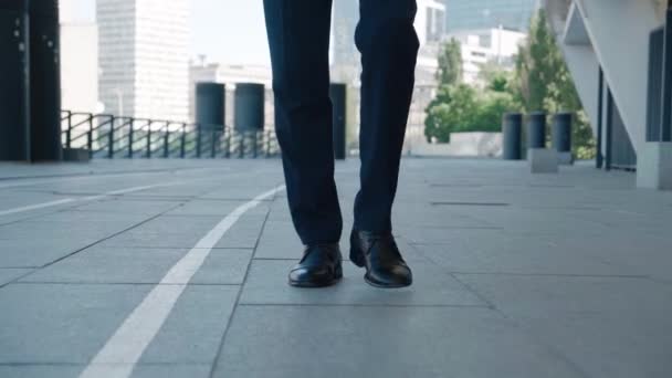 İşe gidip gelen bir iş adamının önü. Deri ayakkabılı ve resmi takım elbiseli kendine güvenen bir girişimci iş yerinin caddesi boyunca yürür. — Stok video