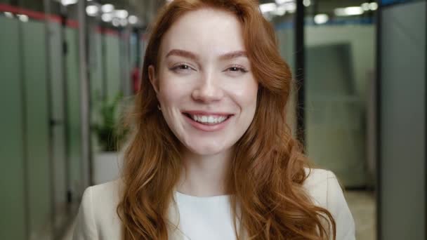 Bella rossa sorridente giovane donna bel viso guardando la fotocamera in posa da sola in ufficio, felice studentessa millenaria professionista da vicino. Indossare abiti formali — Video Stock
