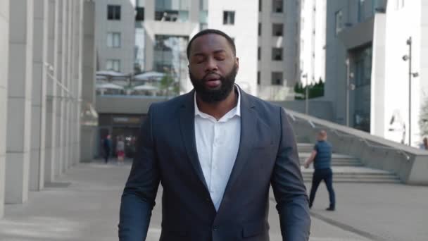 Портрет разочарованного афроамериканского бизнесмена, делающего Facepalm Gesture, реагирующего на потерю, стоя на улице в деловом районе — стоковое видео