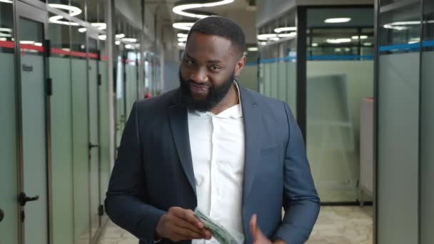 Χαμογελώντας Αφροαμερικανός επιχειρηματίας βγάζει δολάρια από την τσέπη του και τα μετράει. Επιτυχής έννοια κέρδους — Αρχείο Βίντεο