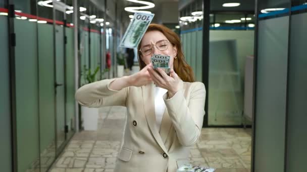 Szczęśliwa bizneswoman stojąca w biurze, rzucająca pieniędzmi w powietrze, świętująca sukces. Młoda uśmiechnięta kobieta robiąca deszcz pieniędzmi przy współpracownikach. Zwolnione tempo. — Wideo stockowe