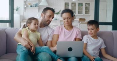 Afrikalı Amerikalı kadınlar internette yazı yazıp sörf yapıyor ve kocasından tavsiye istiyor. Mutlu baba ekranda parmağıyla işaret ediyor. Ekrana bakan tatlı bir çocuk ve ailesi..