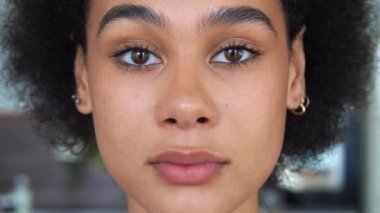 Siyah saçlı, melez, Afro-Amerikan etnik kökenli, kameraya bakan genç bir kadının yakın plan portresi. Kameraya güvenle bakan genç ve güzel bir kadının sakin bakışına odaklan..