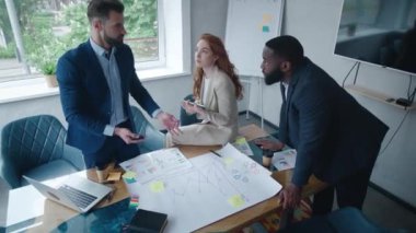 Çok ırklı genç yaratıcı insanlardan oluşan bir grup modern ofiste yeni bir başlangıç projesi ya da şirket stratejisi planlaması üzerine iş görüşmeleri yapıyor. İş arkadaşı takım çalışması konsepti.