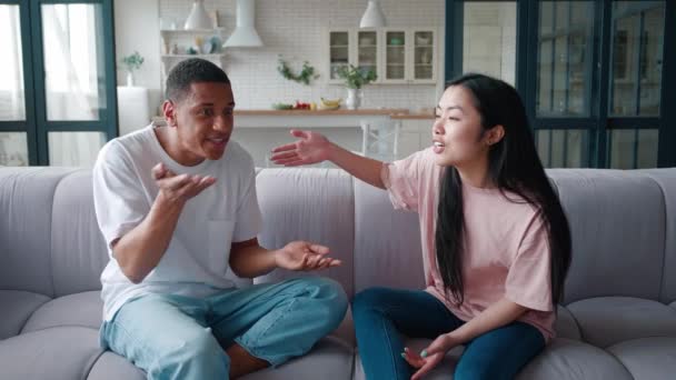 Joven pareja multirracial peleando en casa, chico afroamericano y mujer asiática discutiendo, teniendo confrontación, opuesto pont de vista. Concepto de dificultades de relación familiar. Conflicto en casa. — Vídeo de stock