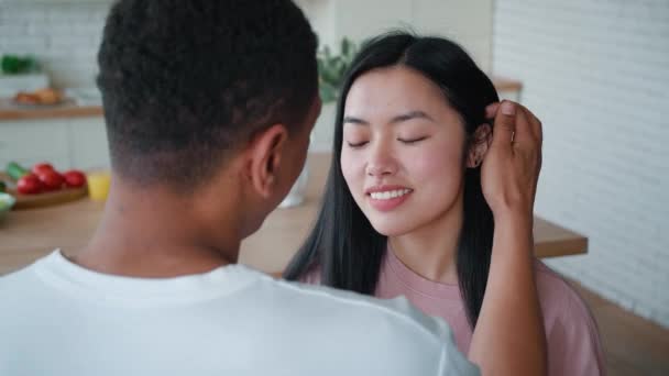 Una vista posterior de un irreconocible hombre afroamericano acariciando suavemente a su joven y hermosa novia asiática por el pelo. Concepto de amor, ternura, cuidado y afecto en las relaciones amorosas — Vídeo de stock