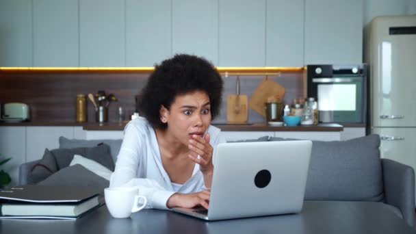 Choqué femme métissée travaillant à distance à la maison avec un ordinateur portable, horrifié par les mauvaises nouvelles soudaines. Femme bouleversée dans des sentiments frustrés de ce qu'elle a vu sur l'écran de l'écran — Video