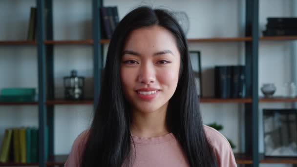 Detail, tvář portrét krásné asijské dívky, dáma, mladá žena dívá do kamery a usmívá se na moderním kancelářském pozadí — Stock video