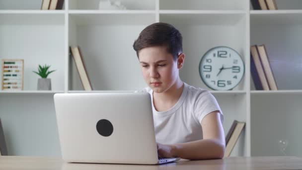 Şok olmuş 13 yaşındaki bir çocuk evdeki masada oturan bir dizüstü bilgisayarın ekranında gördüklerinden korkuyor. Bilgisayardaki içeriği görünce şaşıran bir genç.. — Stok video